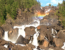 Rocky waterfall and rainbow in Altai